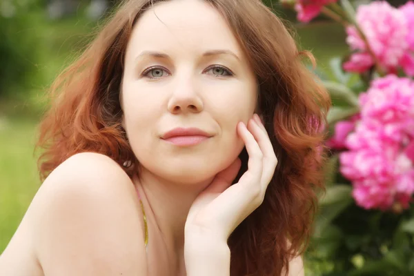 Mulher com flores posando no parque de verão — Fotografia de Stock