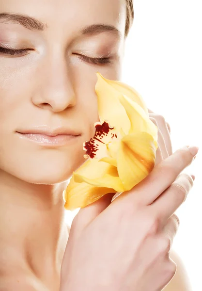 Hermosa mujer con flor de orquídea — Foto de Stock