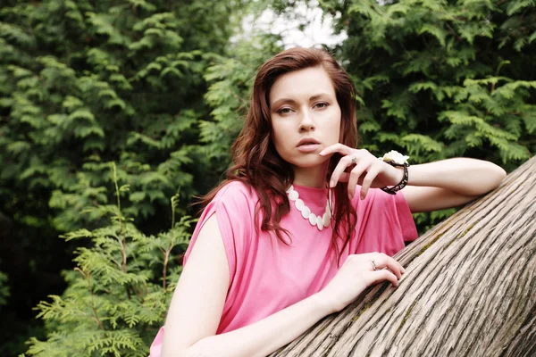 Jeune femme posant sur un arbre — Photo