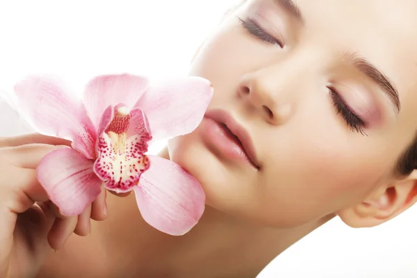 Mujer joven con orquídea rosa — Foto de Stock