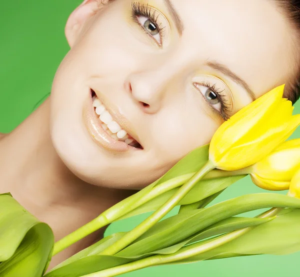 Mulher com flores amarelas no fundo verde — Fotografia de Stock