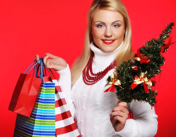 Mujer sosteniendo regalo y el árbol — Foto de Stock