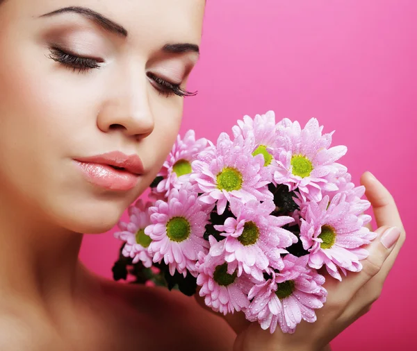 Junge Frau porträtiert mit rosa Chrysanthemen — Stockfoto