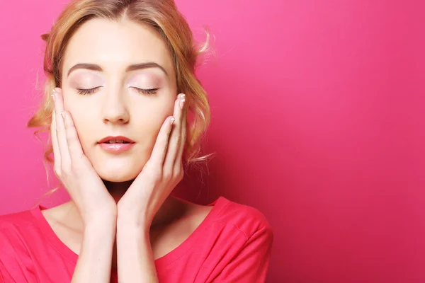 Young woman over pink background — Stok fotoğraf