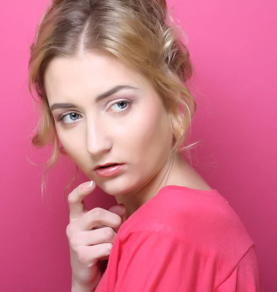 Young woman over pink background — Stockfoto