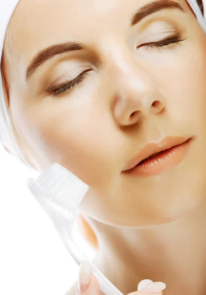 Girl cleaning face with peeling brush — Stock Photo, Image