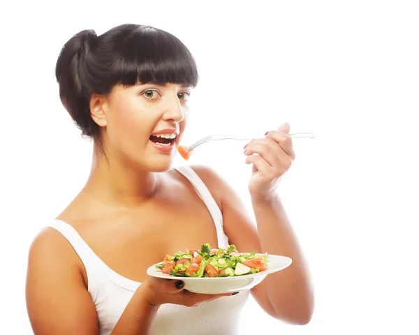 Young happy woman eating salad. Stock Photo