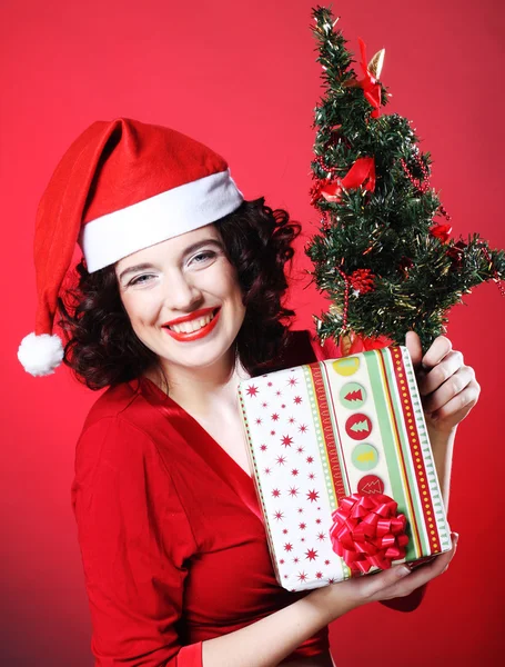 Mujer con sombrero de Santa sosteniendo bolsas de compras —  Fotos de Stock