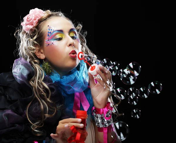 Vrouw met creatieve make-up zeepbellen blazen. — Stockfoto