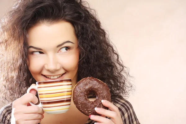 Woman holding donut and coffee in hand — Stock Photo, Image