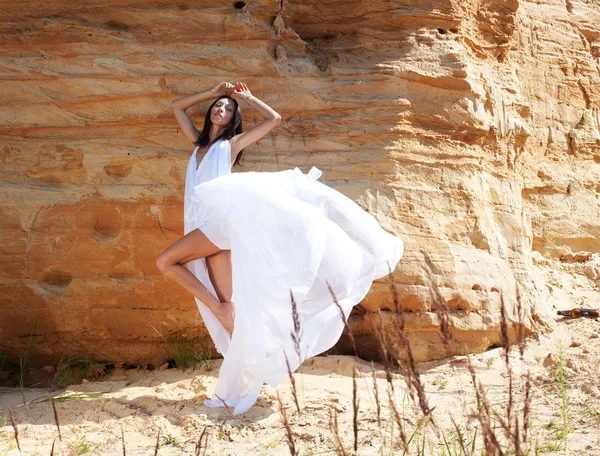 Woman in white dress dancing on the desert — Stock Photo, Image