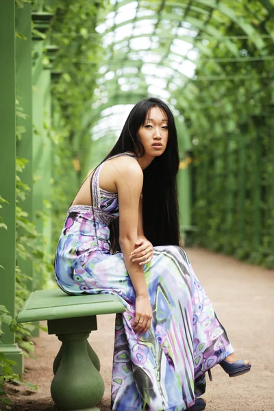 Aziatische vrouw zitten op de parkbank — Stockfoto