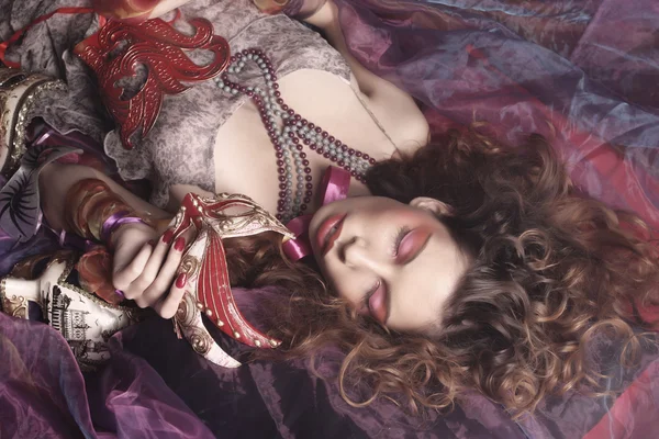 Сексуальная женщина в венецианских масках лежала на органзе — стоковое фото