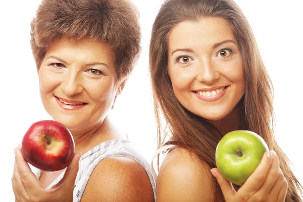 Middle age woman with her daughter holding apples — Stock Photo, Image