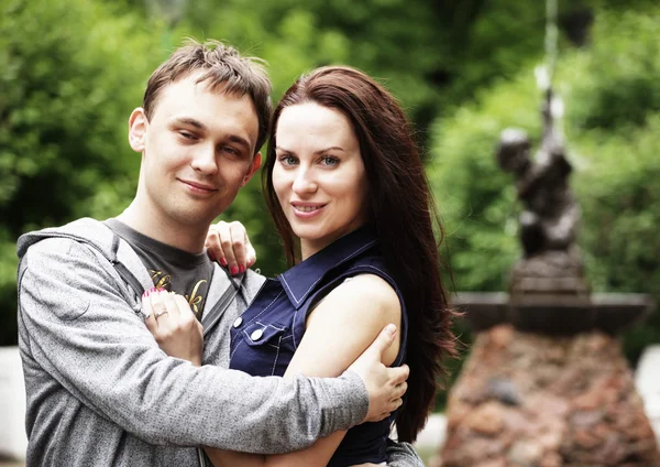 Liebendes junges Paar sitzt an einem Brunnen — Stockfoto