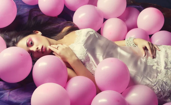 Sleeping woman lying on floor among balloons — Stock Photo, Image