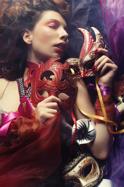 Sexy woman with venetian masks lay on organza — Stock Photo, Image