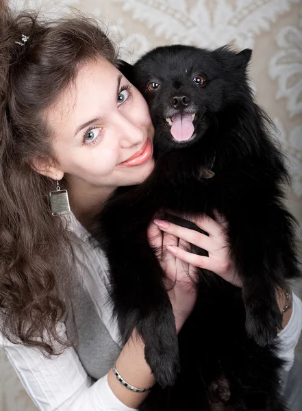 Vrouw bedrijf zwarte hond — Stockfoto