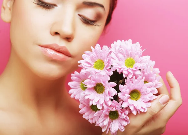 Junge Frau porträtiert mit rosa Chrysanthemen — Stockfoto