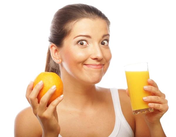 Молода щаслива жінка п'є апельсиновий сік . — стокове фото