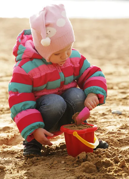 Dziewczynka gra z piasku na plaży jesień — Zdjęcie stockowe