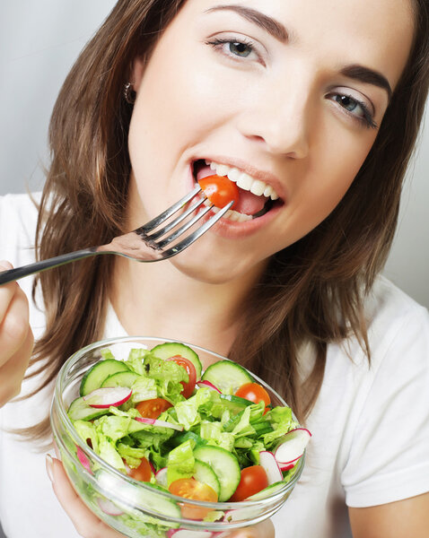 Happy woman eating salad