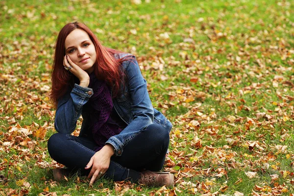 Fiatal csinos nő pihentető az őszi parkban — Stock Fotó