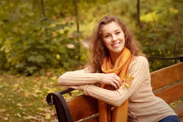 Mladí elegantní žena sedící na lavičce — Stock fotografie