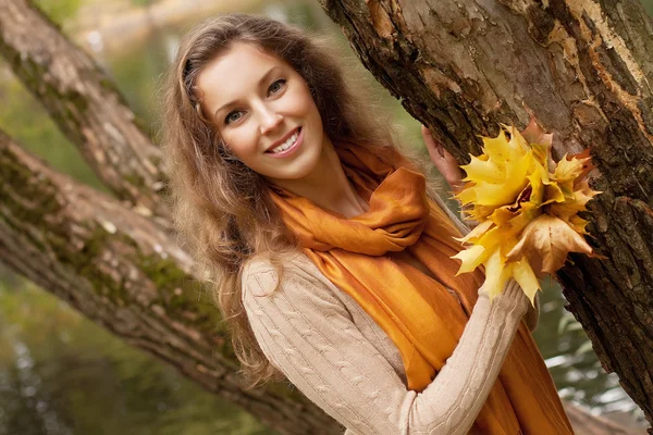 Jonge lachende vrouw in herfst park — Stockfoto