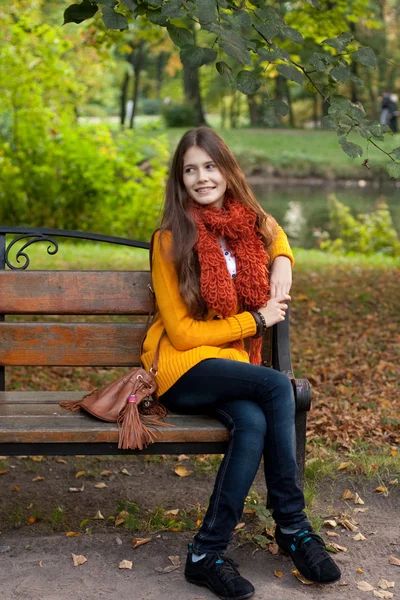 Sonbahar parkında bankta oturan kız. — Stok fotoğraf