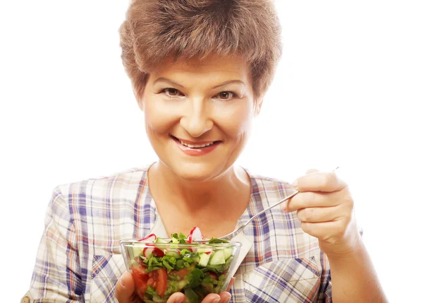 Ältere lächelnde Frau isst Salat — Stockfoto