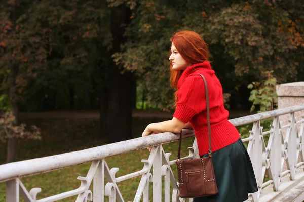 Femme de mode sur le pont dans le parc d'automne — Photo