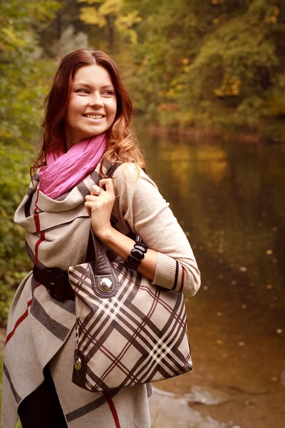 Happy woman near the river in autumn season — Stock Photo, Image