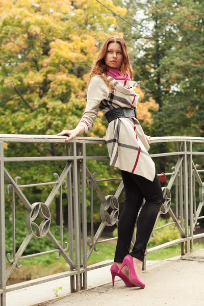 Mode kvinna på bron i höstparken — Stockfoto