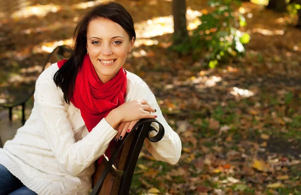 Mädchen auf Bank im Herbstpark — Stockfoto