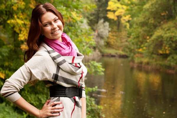 Happy woman near the river in autumn season — Stock Photo, Image