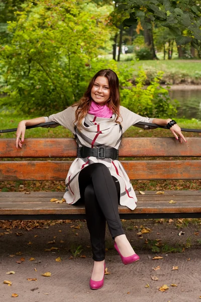 Ragazza in panchina nel parco autunnale — Foto Stock