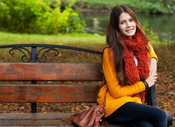 Mädchen auf Bank im Herbstpark — Stockfoto