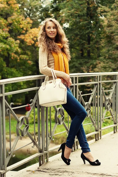 Mulher de moda na ponte no parque de outono — Fotografia de Stock