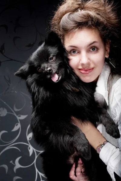 Woman holding black dog — Stock Photo, Image