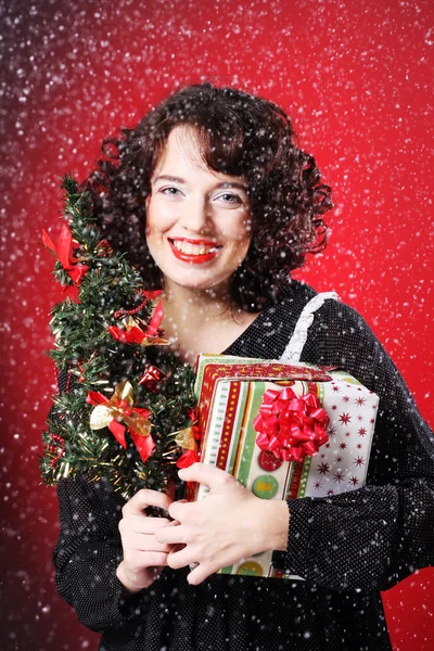 Mujer sosteniendo regalo y el árbol — Foto de Stock