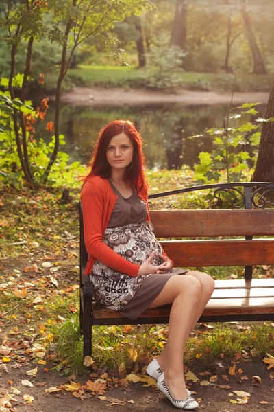 Sonbahar parkında yürüyen hamile bir kadın. — Stok fotoğraf