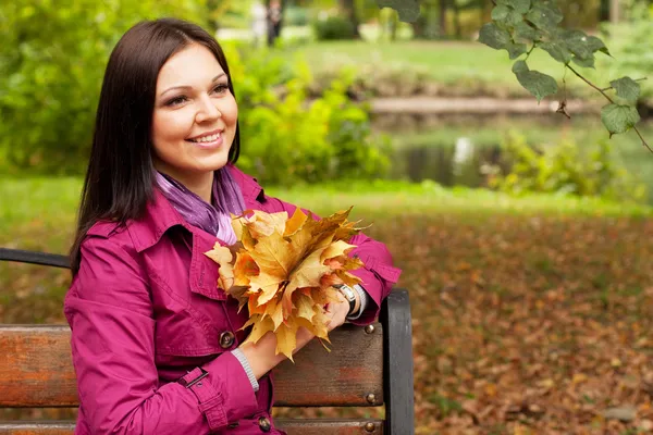 Jonge elegante vrouw met herfst bladeren — Stockfoto