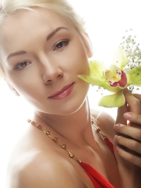 Mulher loira bonita com flor de orquídea verde — Fotografia de Stock