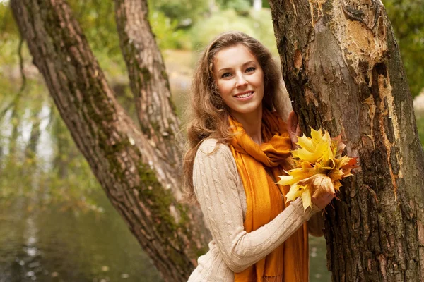 Jonge lachende vrouw in herfst park — Stockfoto