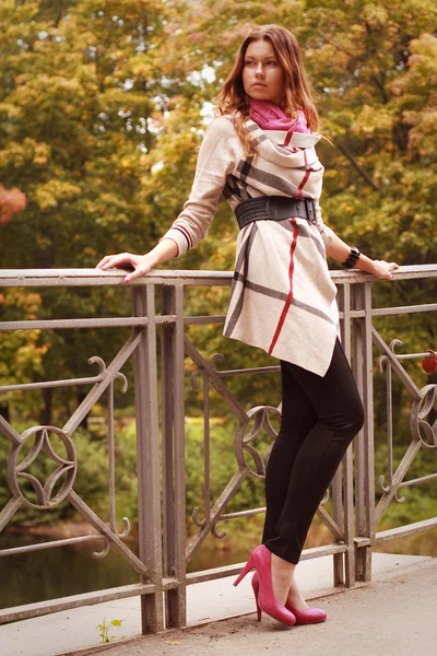 Modefrau auf Brücke im Herbstpark — Stockfoto