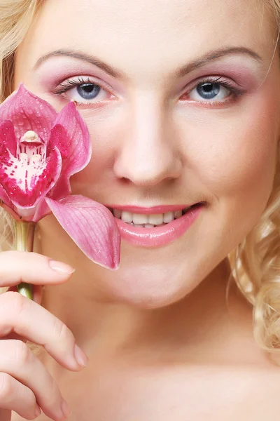 Schöne Frau mit rosa Blume — Stockfoto