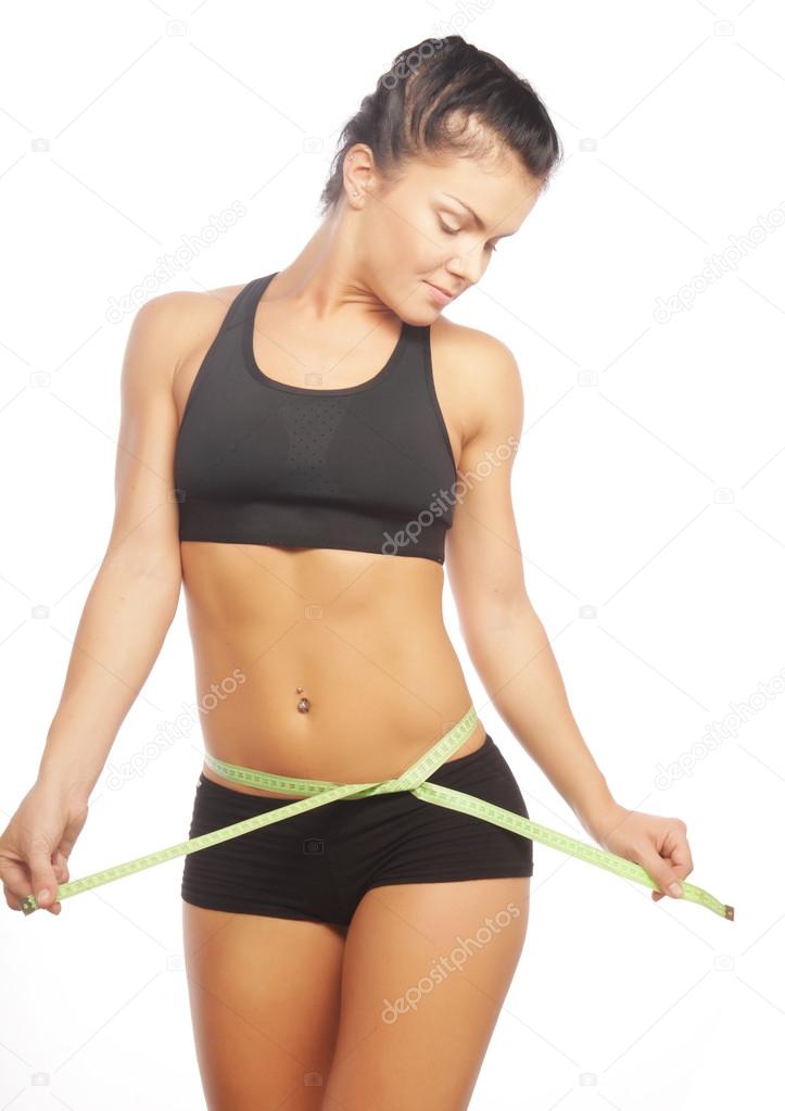 Beautiful sporty woman looking at measure