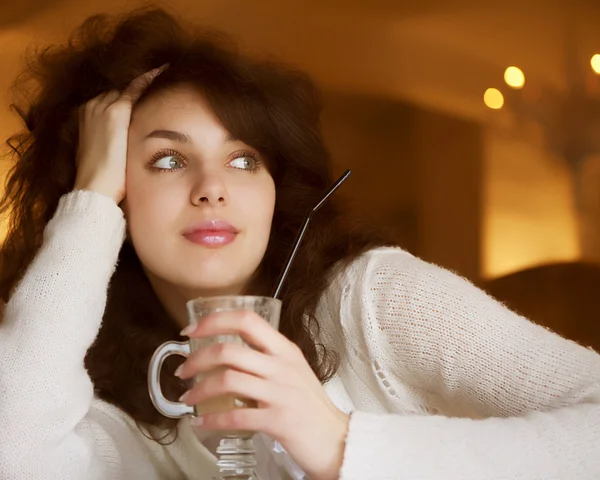 Молода жінка насолоджується лате кавою в кафе — стокове фото