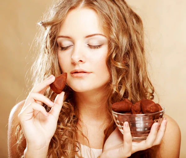 Blond girl in act to eat a chocolate candy — Stock Photo, Image